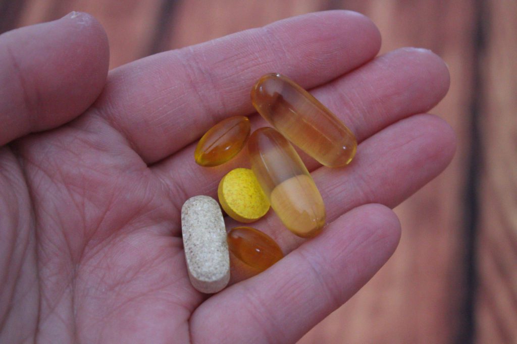 Close up of hand holding vitamins