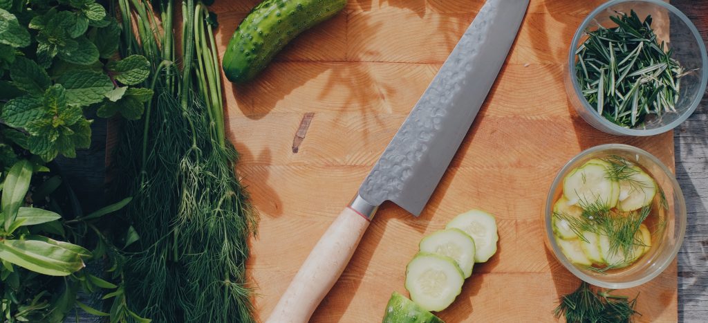 Cutting board with knife and green vegetables