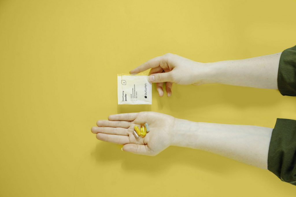 Two hands holding Autumn DNA custom vitamin packet.