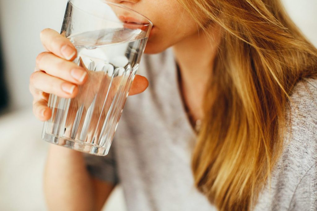 Close up of a woman drinking a glass of water