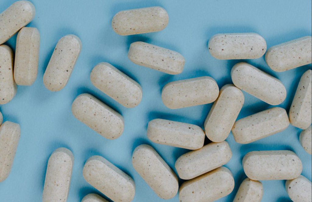 Several grey pills scattered on a blue background