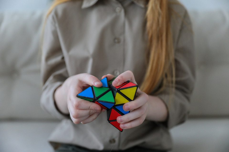 a woman playing with a brain teaser toy