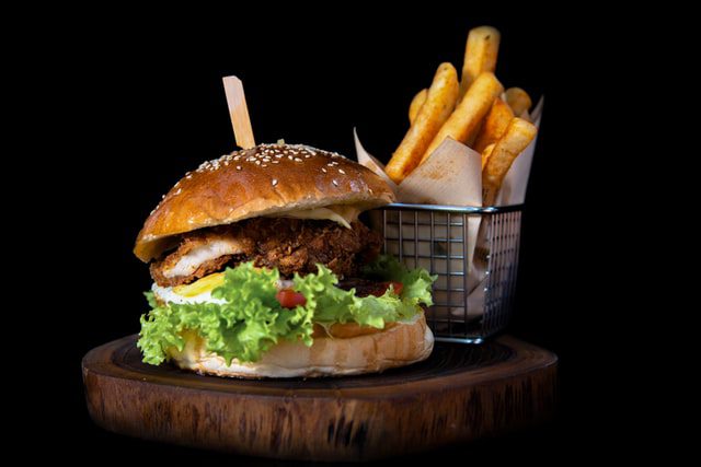 A fast-food burger, fries, and soda on a tray.